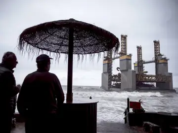 Los dueños de un chiringuito observan la gabarra Los dueños de un chiringuito observan la gabarra