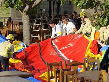 Varios operarios y bomberos retiran el castillo hinchable del restaurante Mas Oller Varios operarios y bomberos retiran el castillo hinchable del restaurante Mas Oller