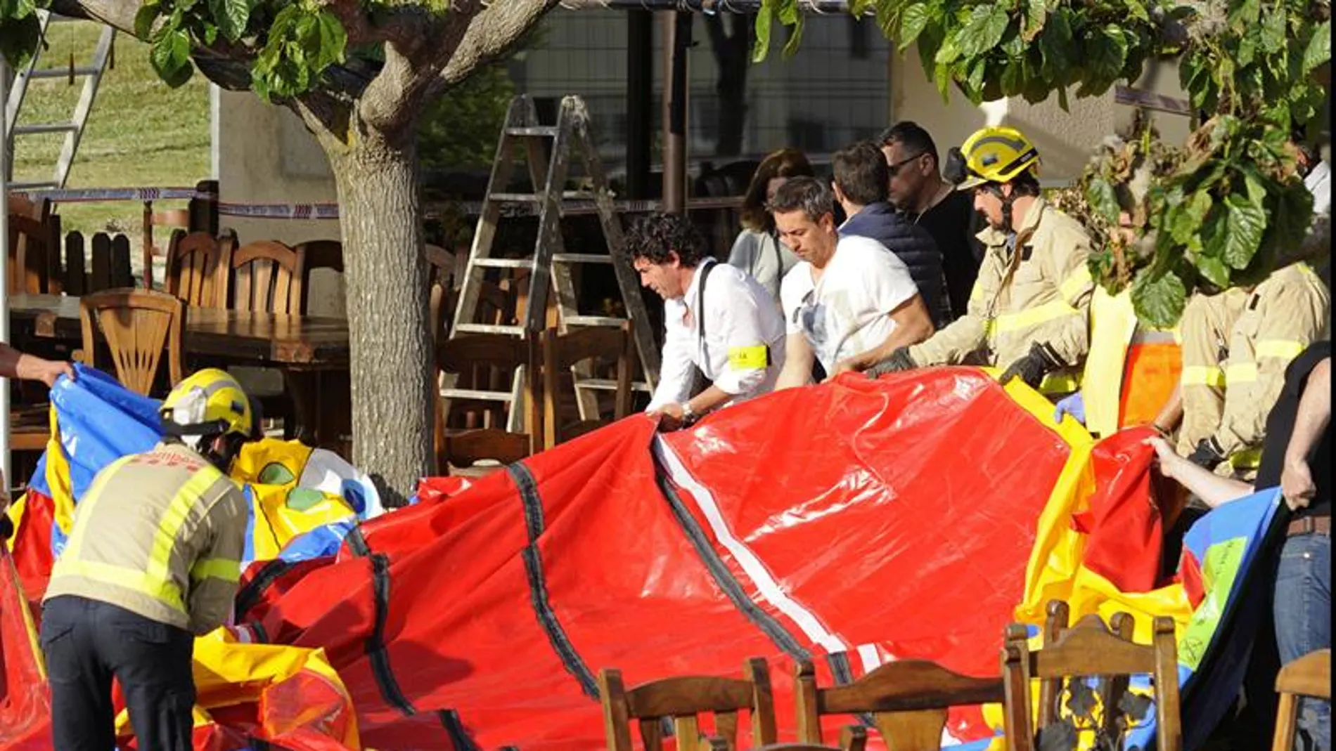 Varios operarios y bomberos retiran el castillo hinchable del restaurante Mas Oller Varios operarios y bomberos retiran el castillo hinchable del restaurante Mas Oller