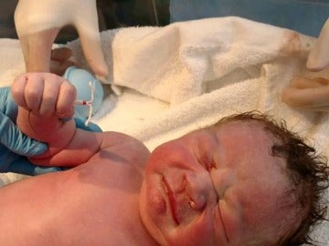 El bebé con el dispositivo anticonceptivo en la mano