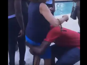 El joven cogiendo a la mujer para lanzarla a la piscina El joven cogiendo a la mujer para lanzarla a la piscina