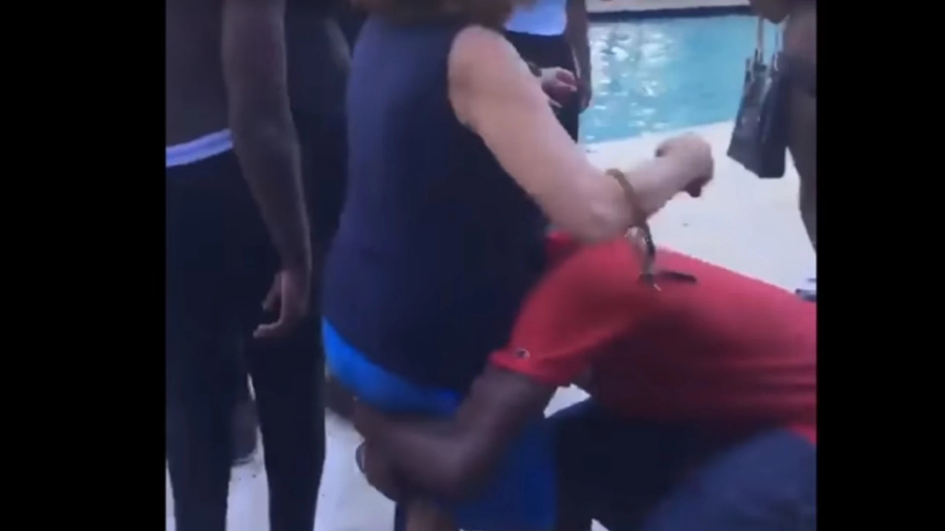 El joven cogiendo a la mujer para lanzarla a la piscina El joven cogiendo a la mujer para lanzarla a la piscina