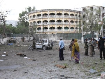 Varias personas permanecen en el lugar donde ha hecho explosión un coche bomba en un punto de control de Mogadiscio