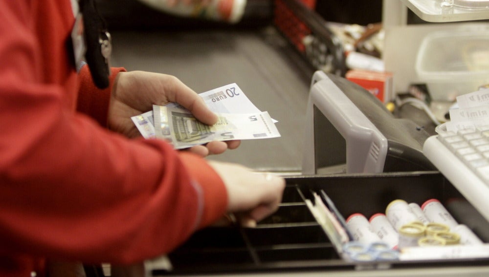 Una cajera devuelve el cambio a un cliente