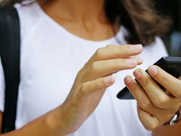Una usuaria con su teléfono móvil Una usuaria con su teléfono móvil