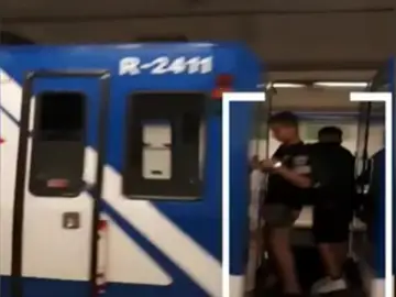 Dos niños viajan entre dos vagones del Metro de Madrid Dos niños viajan entre dos vagones del Metro de Madrid