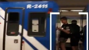 Dos niños viajan entre dos vagones del Metro de Madrid
