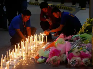 Filipinos depositan flores y velas en el Resorts World Manila despés del asalto Filipinos depositan flores y velas en el Resorts World Manila despés del asalto