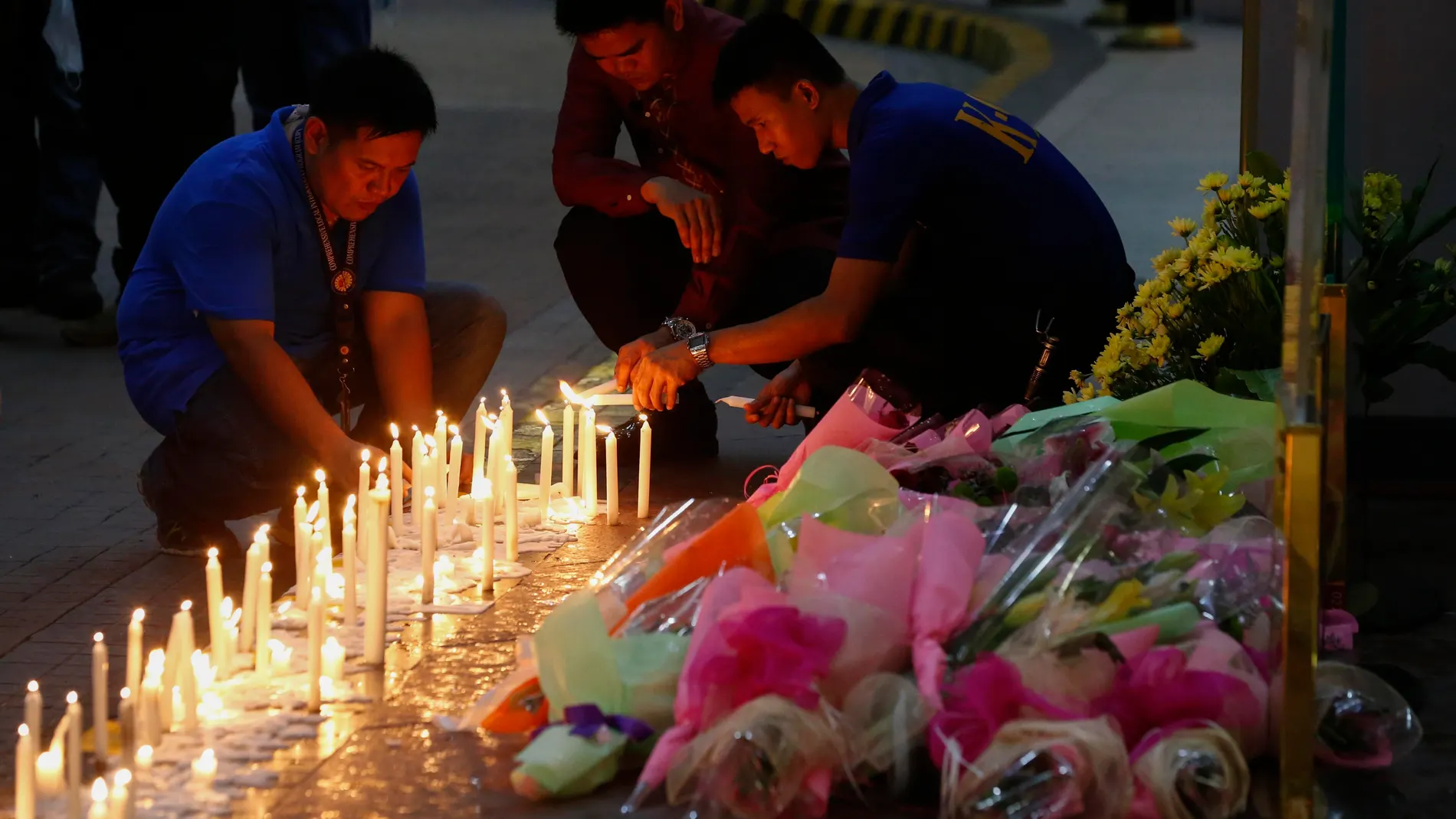 Filipinos depositan flores y velas en el Resorts World Manila despés del asalto Filipinos depositan flores y velas en el Resorts World Manila despés del asalto