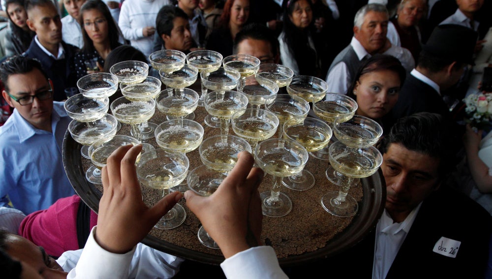 Un camarero llevando copas en una boda