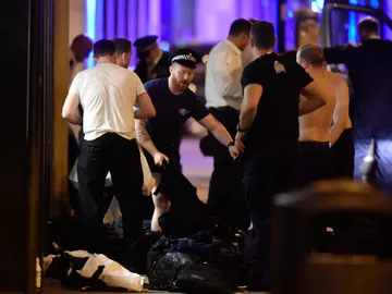 Agentes de policía se cambian para ayudar en las labores de auxilio en el doble atentado de Londres Agentes de policía se cambian para ayudar en las labores de auxilio en el doble atentado de Londres