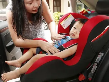 Un niño en un sistema de retención infantil en el coche Un niño en un sistema de retención infantil en el coche