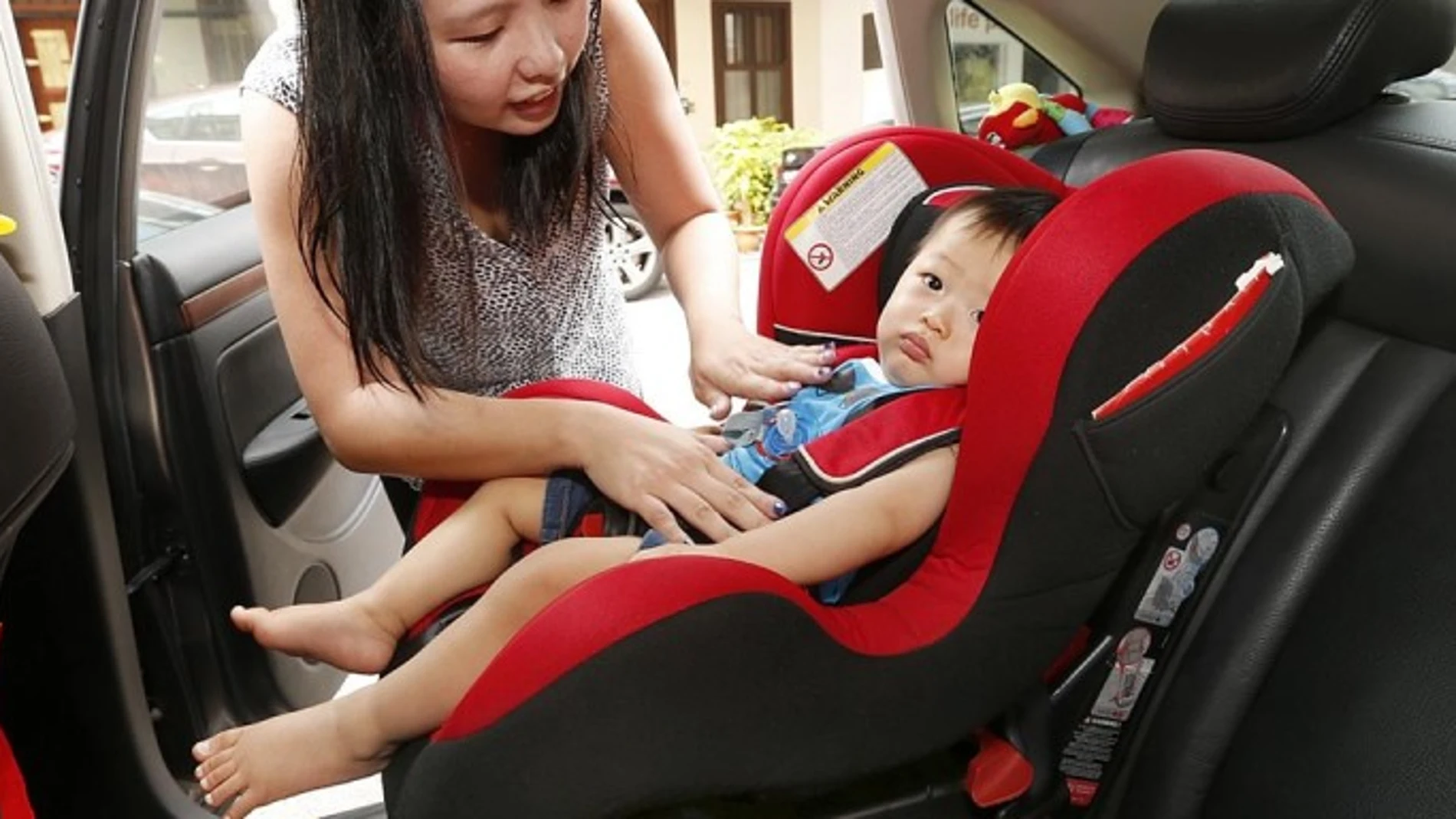 Un niño en un sistema de retención infantil en el coche Un niño en un sistema de retención infantil en el coche