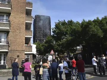 Varias personas observan la Torre Grenfell tras apagarse el incendio Varias personas observan la Torre Grenfell tras apagarse el incendio