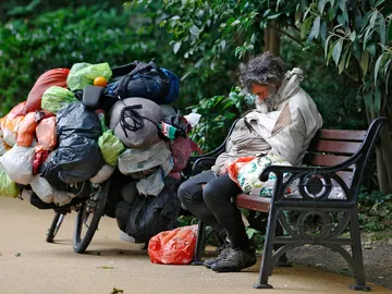 Un indigente durmiendo en un banco Un indigente durmiendo en un banco