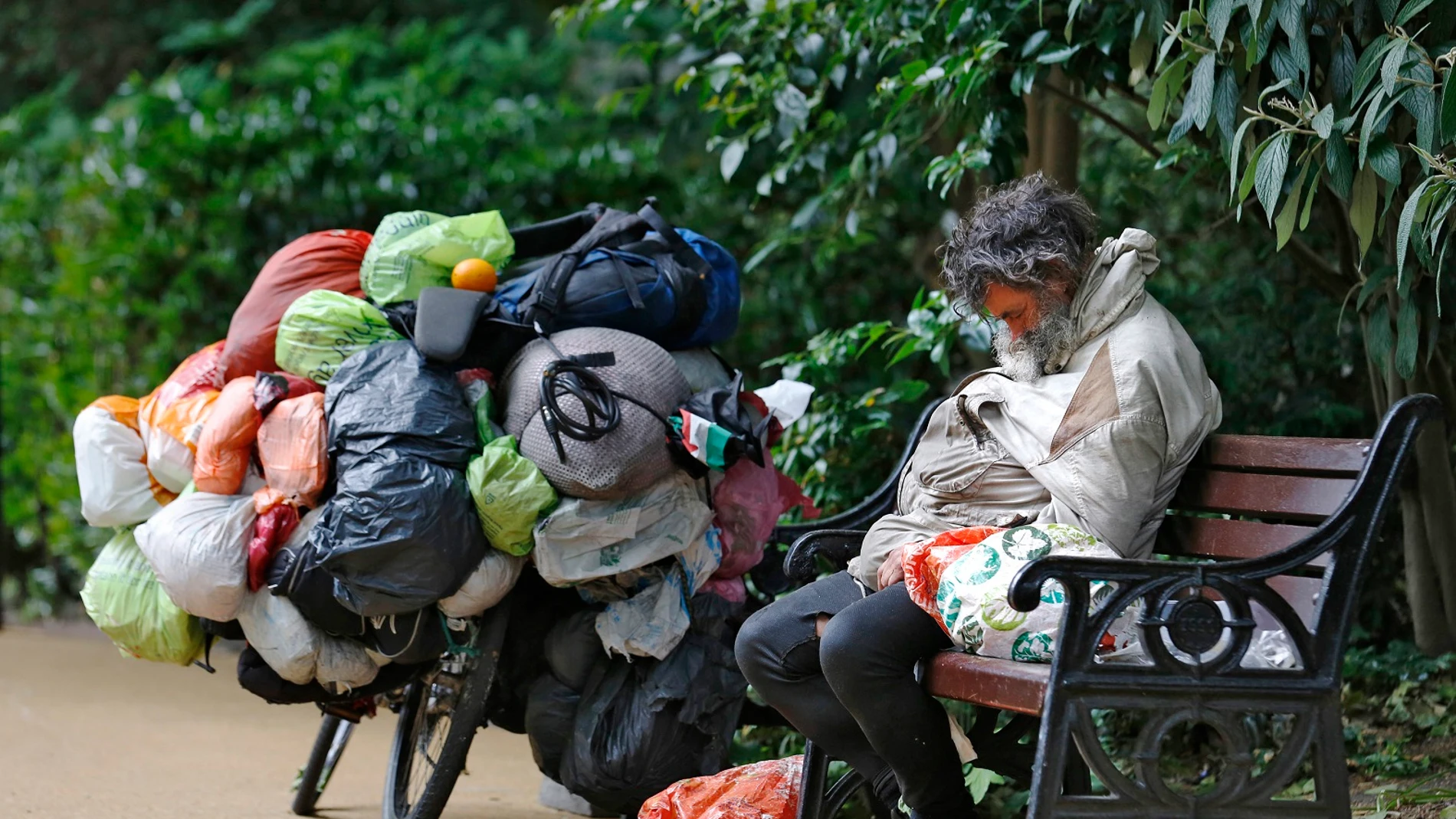 Un indigente durmiendo en un banco Un indigente durmiendo en un banco