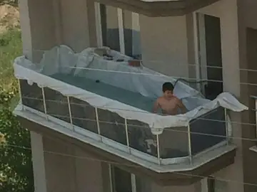 Piscina improvisada de un niño en el balcón de casa Piscina improvisada de un niño en el balcón de casa