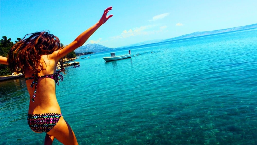Chica saltando en la playa