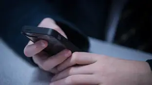 Un niño consulta un teléfono móvil (Archivo) Un niño consulta un teléfono móvil (Archivo)