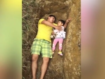 Padre con su hija en el hueco de la tumba
