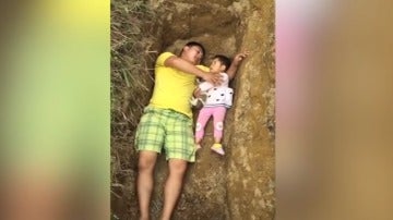 Padre con su hija en el hueco de la tumba