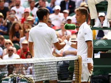 Djokovic saluda a Kilzan tras la lesión de éste último Djokovic saluda a Kilzan tras la lesión de éste último
