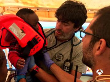 Jordi Villacampa ayuda a un pequeño refugiado en un barco en el Mediterráneo