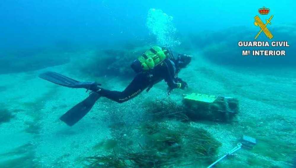 Un buzo de la Guardia Civil inspecciona el artefacto explosivo