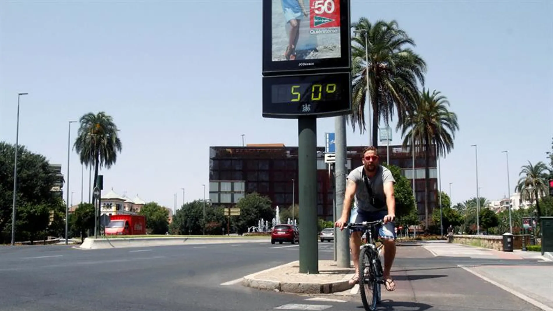 Un joven pasa con su bicicleta junto a un termómetro que marca 50 grados en una calle de Córdoba Un joven pasa con su bicicleta junto a un termómetro que marca 50 grados en una calle de Córdoba