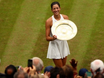 Muguruza sostiene su trofeo de campeona de Wimbledon ante la ovación de la grada