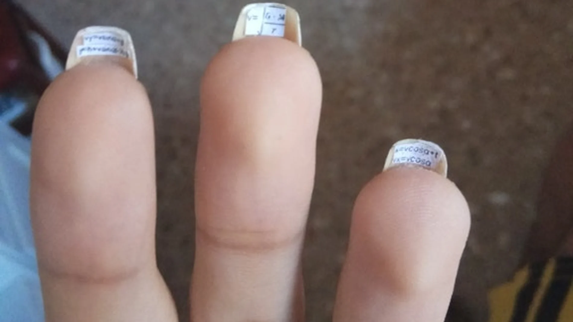 Una chica se pone chuletas bajo las uñas con fórmulas de su examen de ciencias Una chica se pone chuletas bajo las uñas con fórmulas de su examen de ciencias