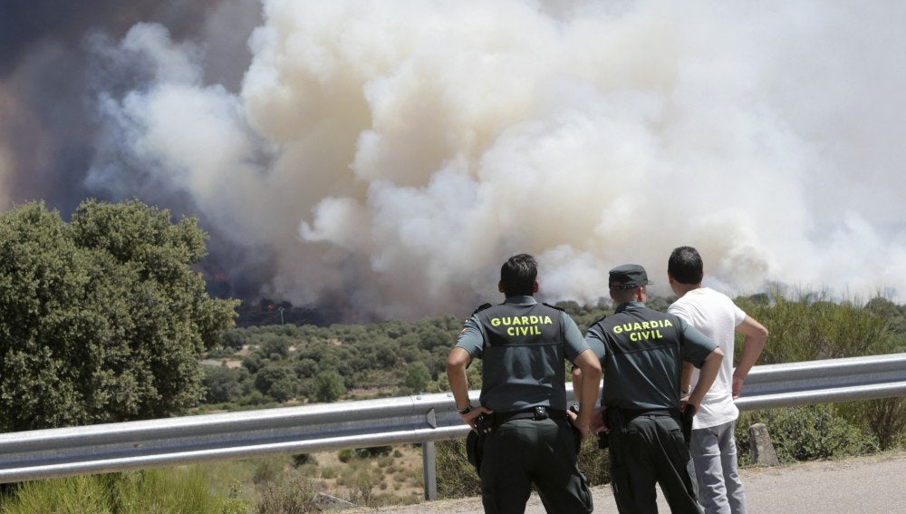 Agentes de la Guardia Civil observan el incendio forestal declarado en la Nacional 122
