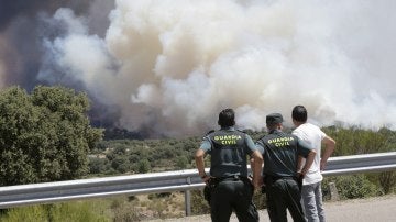 Agentes de la Guardia Civil observan el incendio forestal declarado en la Nacional 122