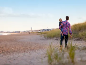 Padre caminado por la playa con su hijo Padre caminado por la playa con su hijo