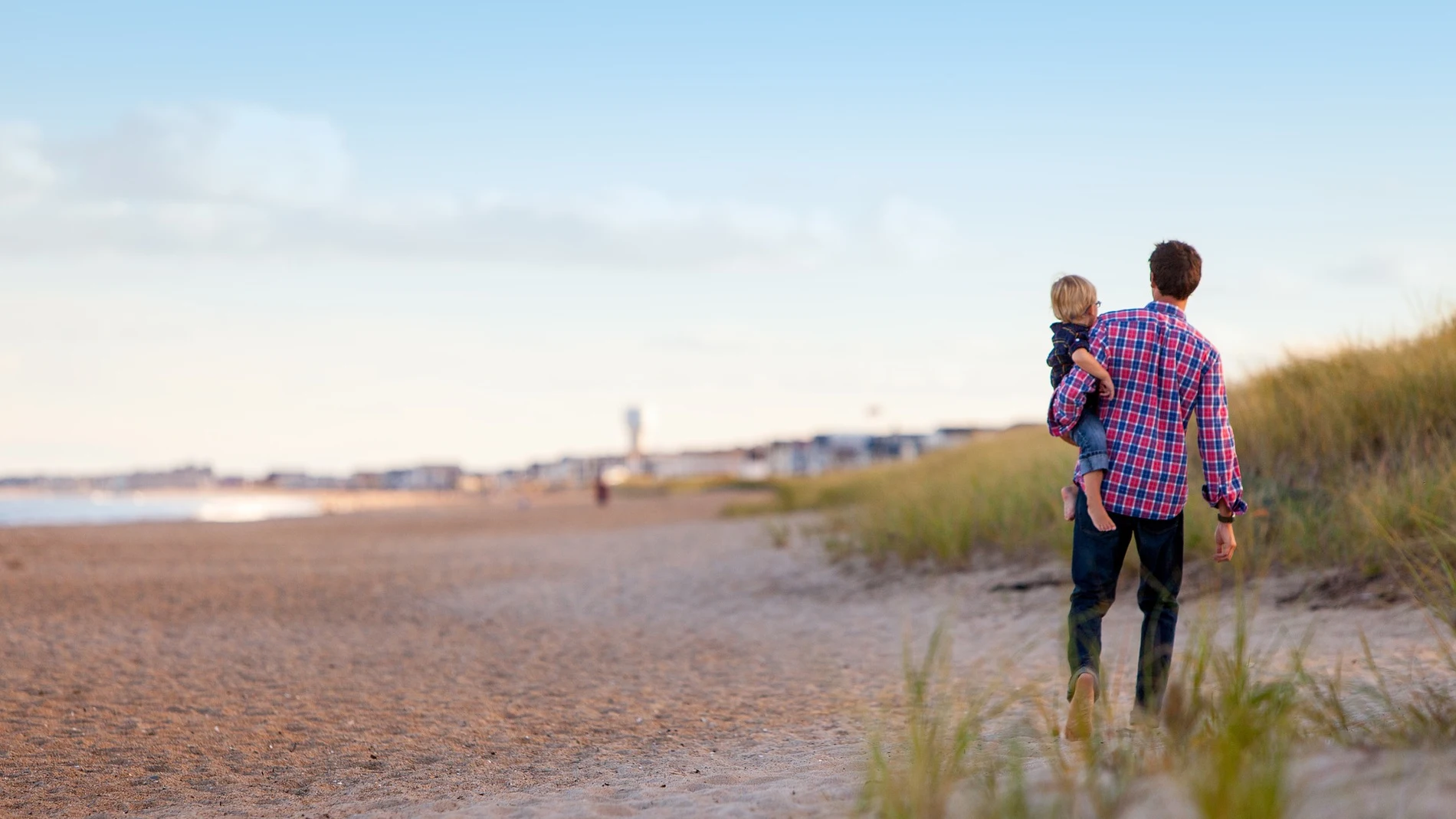 Padre caminado por la playa con su hijo Padre caminado por la playa con su hijo