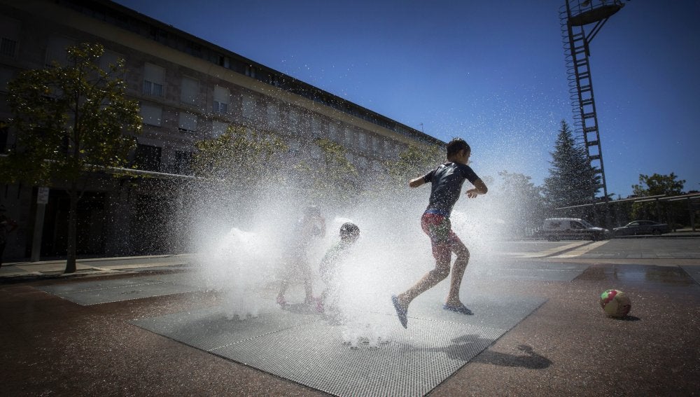 Niños disfrutando del agua de las fuentes