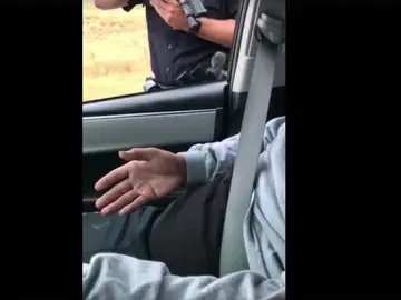 El policía apuntando con el arma al conductor El policía apuntando con el arma al conductor