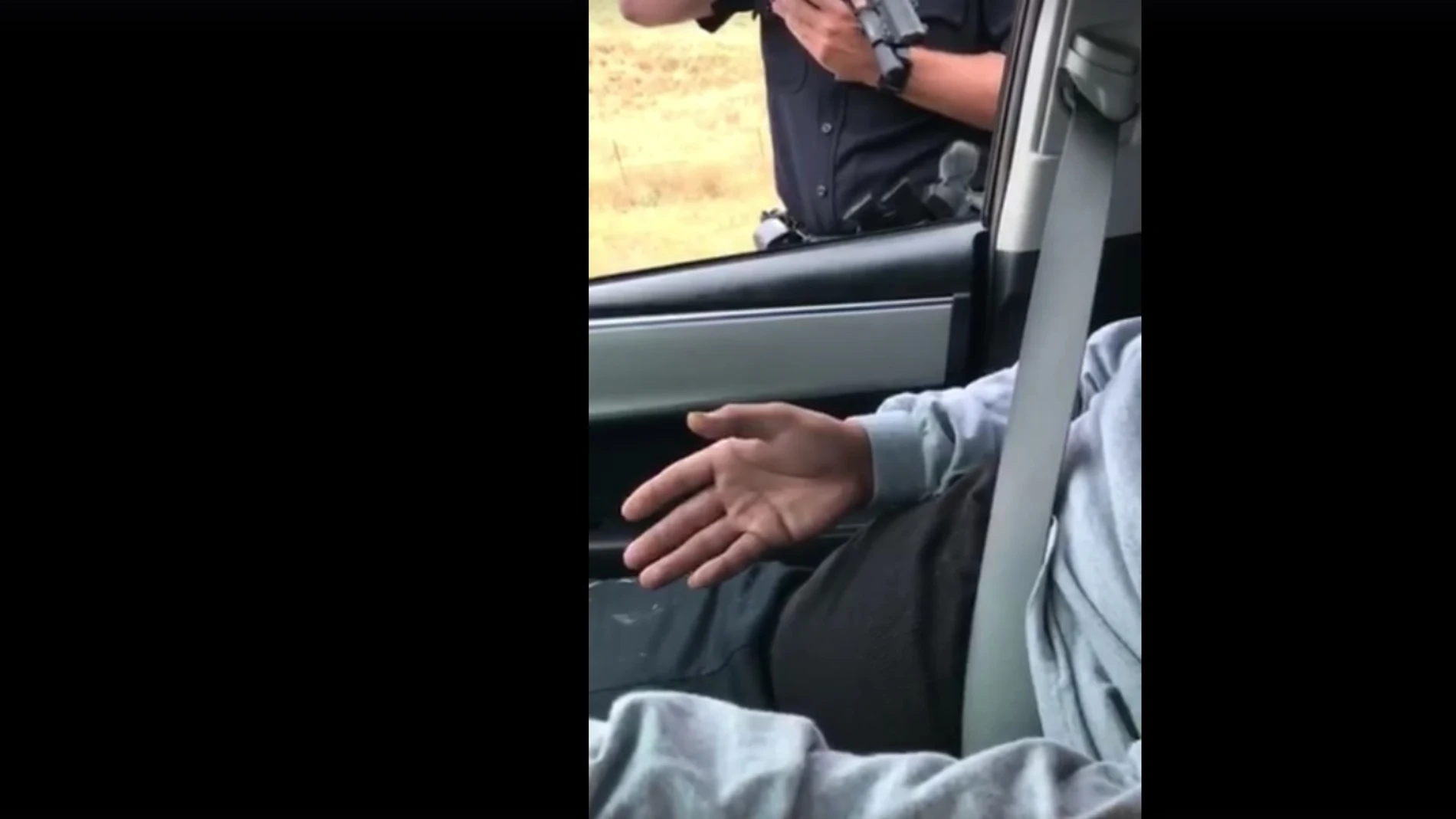 El policía apuntando con el arma al conductor El policía apuntando con el arma al conductor