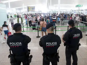 Agentes de los Mossos d'Esquadra controlan de los accesos a las puertas de embarque en el Aeropuerto de El Prat Agentes de los Mossos d'Esquadra controlan de los accesos a las puertas de embarque en el Aeropuerto de El Prat