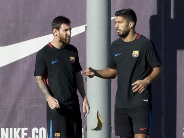 Messi y Luis Suárez hablan durante un entrenamiento con el Barcelona