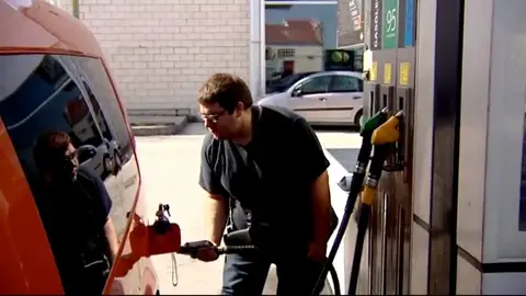 Un vehículo repone combustible en una gasolinera Un vehículo repone combustible en una gasolinera