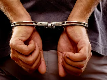 Un hombre detenido con esposas Un hombre detenido con esposas