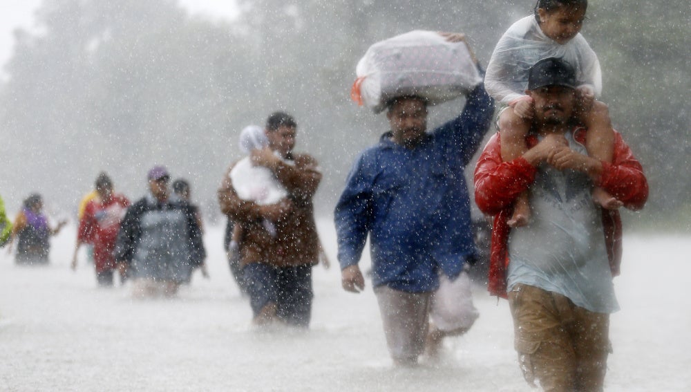 Los residentes, por las zonas inundadas que deja la tormenta tropical Harvey en Beaumont Place, Houston