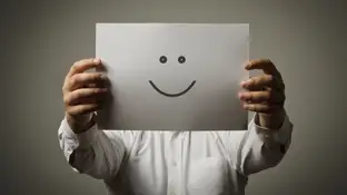 Un hombre sujeta una cara sonriente Un hombre sujeta una cara sonriente