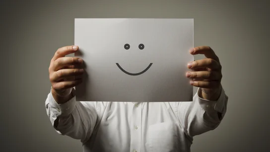 Un hombre sujeta una cara sonriente Un hombre sujeta una cara sonriente