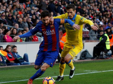 Leo Messi intenta zafarse de Helder Lopes en un Barcelona - Las Palmas