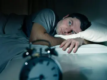 Imagen de archivo de un hombre tratando de dormir. Imagen de archivo de un hombre tratando de dormir.