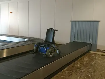 La silla de ruedas, a su paso por la cinta eléctrica La silla de ruedas, a su paso por la cinta eléctrica