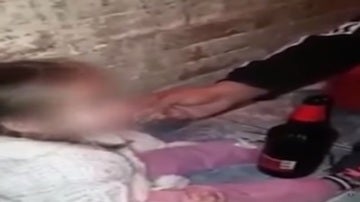 Captura del vídeo en el que se puede ver a los padres dando de fumar y beber a la menor