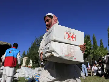 Afgano con cajas de ayuda de la Cruz Roja Afgano con cajas de ayuda de la Cruz Roja